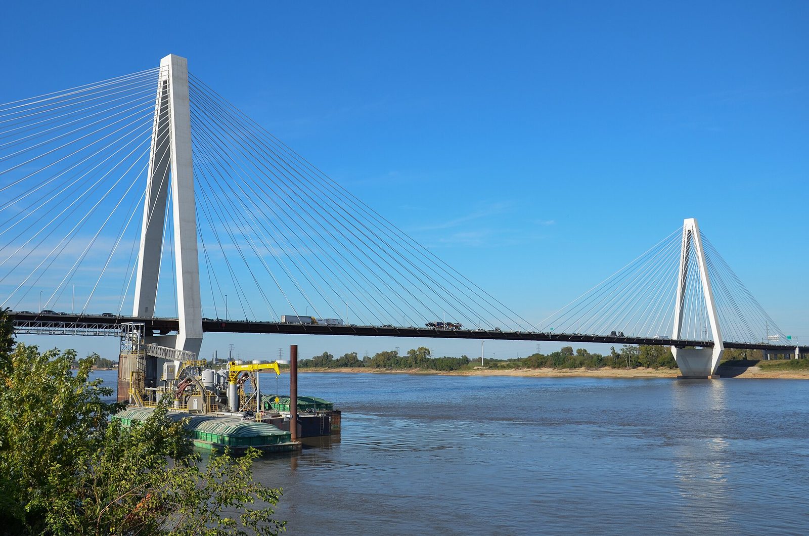 The Stan Musial Veterans Memorial Bridge, a white cable-stayed span carrying I-70 over the Mississippi River under a clear sky